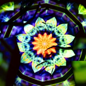 A dynamic and colorful kaleidoscopic mandala art projected onto a woman's silhouette, creating a surreal visual effect.